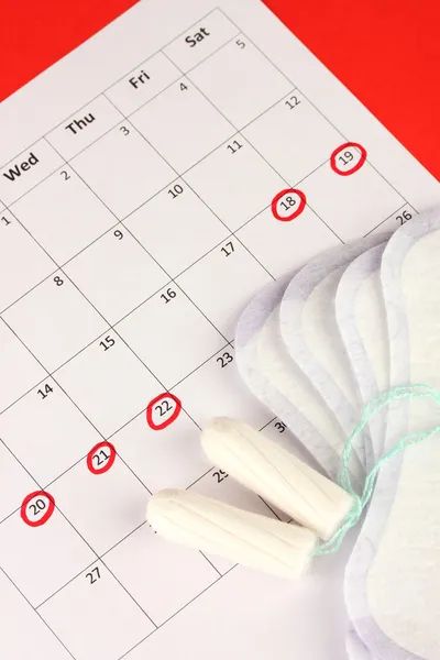 Calendário de menstruação com absorventes e tampões sanitários, close-up — Fotografia de Stock