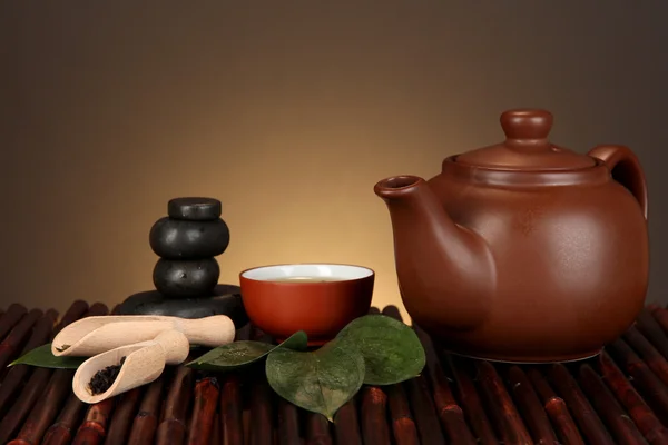 Китайская чайная церемония на бамбуковом столе на коричневом фоне — стоковое фото