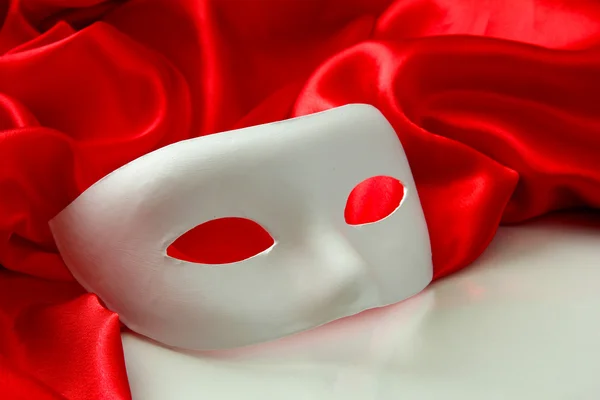 White mask and red silk fabric, isolated on white — Stock Photo, Image