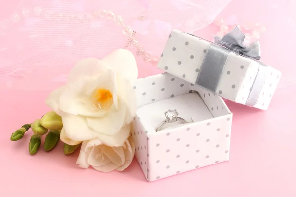 Beautiful box with wedding ring and flower on pink background — Stock Photo, Image