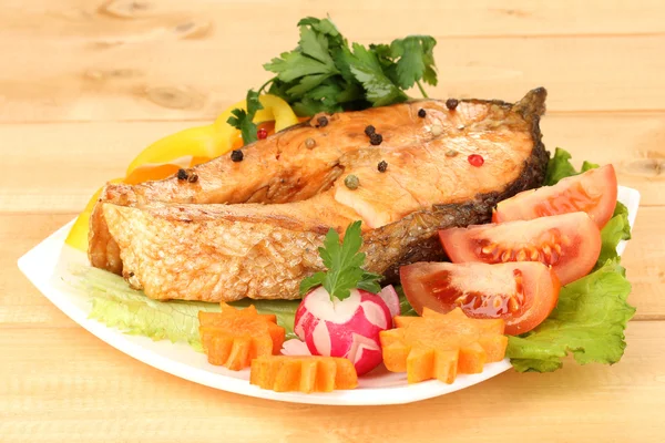 Appetizing grilled salmon with vegetables on wooden table — Stock Photo, Image
