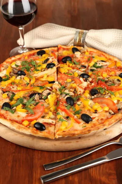 Leckere Pizza mit Wein auf Holztisch in Großaufnahme — Stockfoto