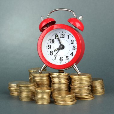 gri arka plan üzerinde paralar ile çalar saat