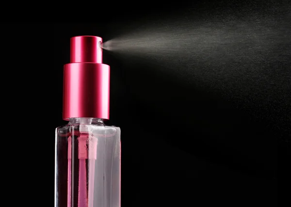 Women's perfume in bottle and spraying, on black background — Stock Photo, Image