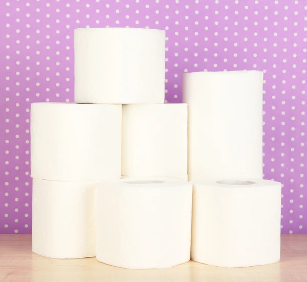 Rolls of toilet paper on purple with dots background — Stock Photo, Image