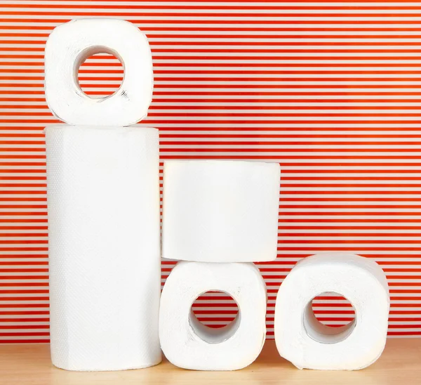 Rolos de papel higiênico sobre fundo vermelho listrado — Fotografia de Stock