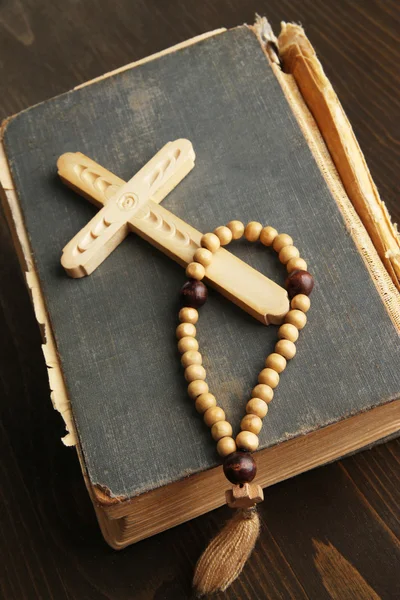 Bibel, Rosenkranz und Kreuz auf Holztisch in Großaufnahme — Stockfoto