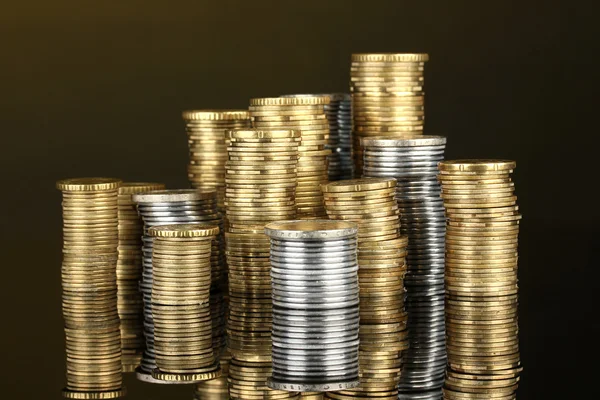 Many coins in columns on dark background — Stock Photo, Image