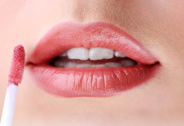 Schöne junge Frau, die Lipgloss aufträgt, Nahaufnahme — Stockfoto
