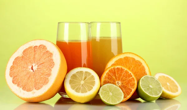 たくさんの熟した柑橘類ジュース緑の背景に — ストック写真