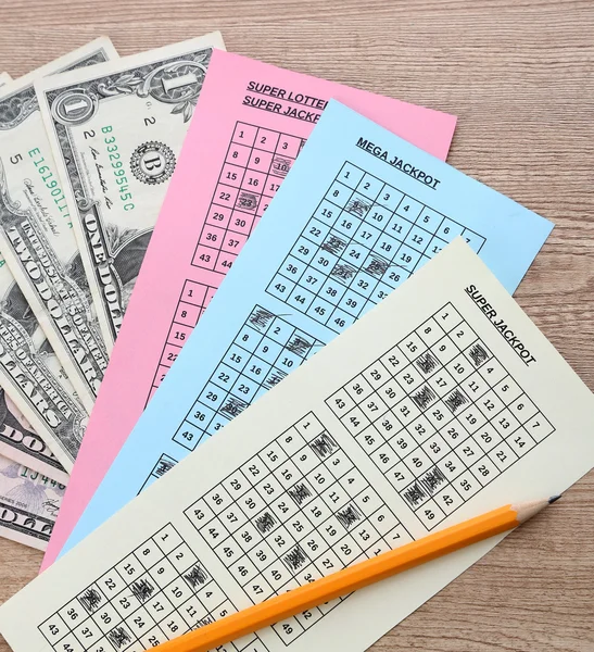 Lottery tickets with pencil and money, on wooden background — Stock Photo, Image