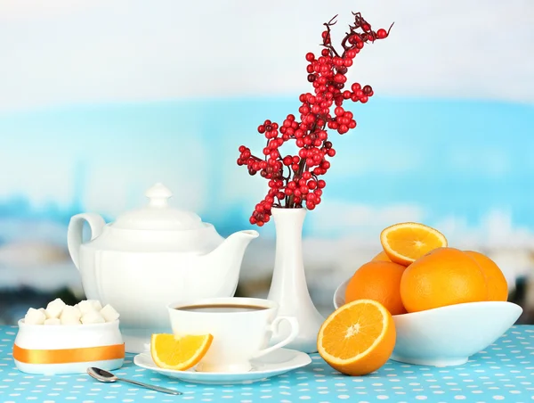 Beautiful white dinner service with oranges on blue tablecloth on natural background — Stock Photo, Image