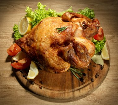 ahşap masa üzerinde plaka üzerinde sebze ile bütün kavrulmuş tavuk
