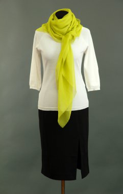 manken üzerinde gri arka plan üzerinde beyaz bluz, siyah etek ve Yeşil fular