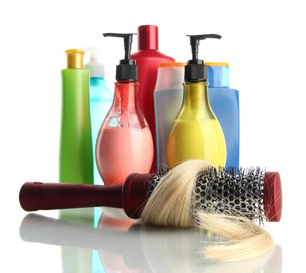 Pinceau peigne avec des cheveux et des bouteilles cosmétiques, isolé sur blanc — Photo