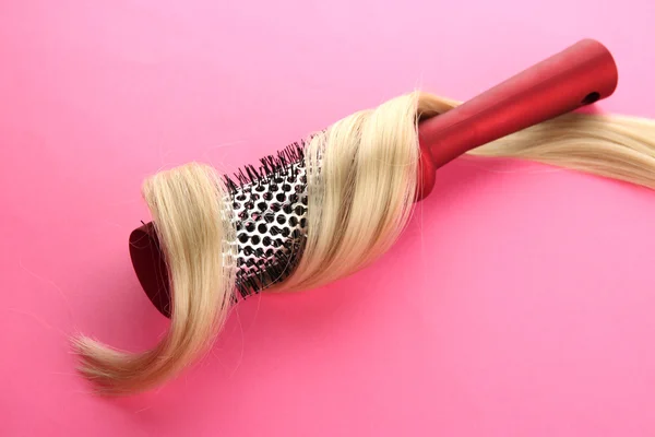 Escova de pente com cabelo, no fundo rosa — Fotografia de Stock