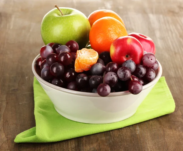 Bowl with fruits, on wooden table — Stock Photo, Image