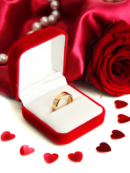 Beautiful box with wedding ring and rose on red silk background