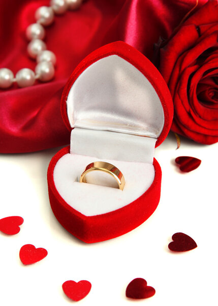 Beautiful box with wedding ring and rose on red silk background