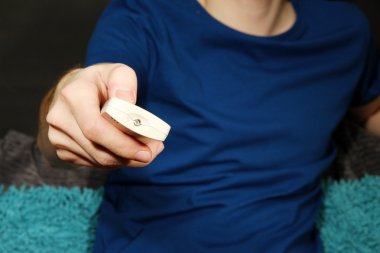 adam el bir tv uzaktan kumanda, koyu arka plan üzerinde tutarak