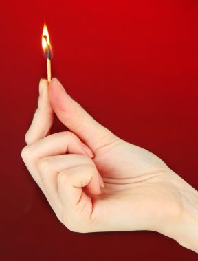 kibriti el, koyu kırmızı zemin üzerine yapılan