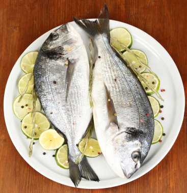 dorado ahşap masa yakın çekim plaka üzerinde limon ile iki balık