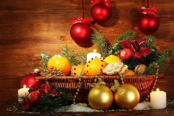 Kerstmis samenstelling in de mand met sinaasappels en fir tree, op houten achtergrond — Stockfoto