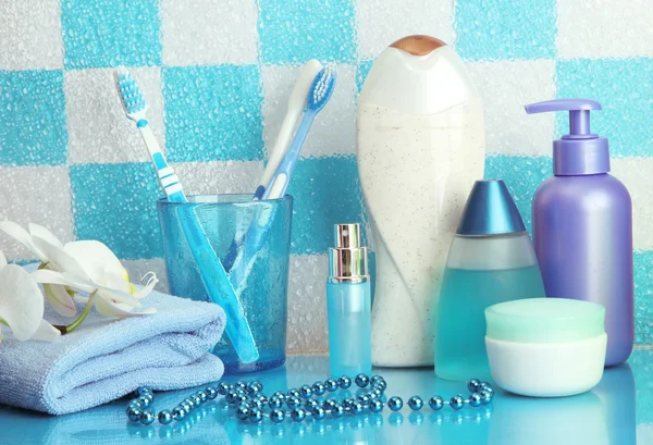 Accesorios de baño en el estante en el baño sobre fondo de pared de azulejo azul —  Fotos de Stock