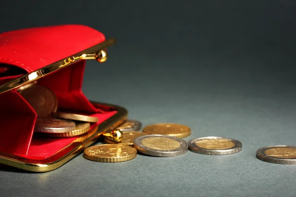 Samice červená peněženka s mincemi na šedém pozadí — Stock fotografie