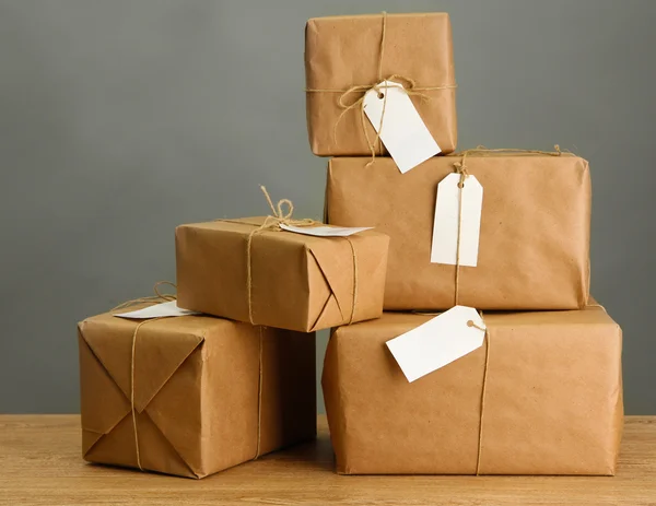 Cajas de paquetes con papel kraft, sobre mesa de madera sobre fondo gris —  Fotos de Stock