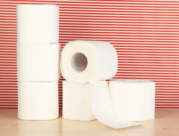 Rolls of toilet paper on striped red background — Stock Photo, Image