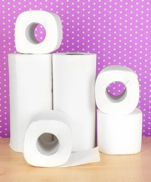 Rolls of toilet paper on purple with dots background — Stock Photo, Image