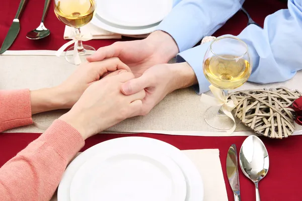 Hands of romantic couple over a restaurant table — Stock Photo, Image