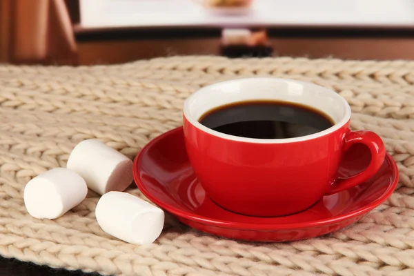 Kopp kaffe med halsduk på bord i rummet — Stockfoto
