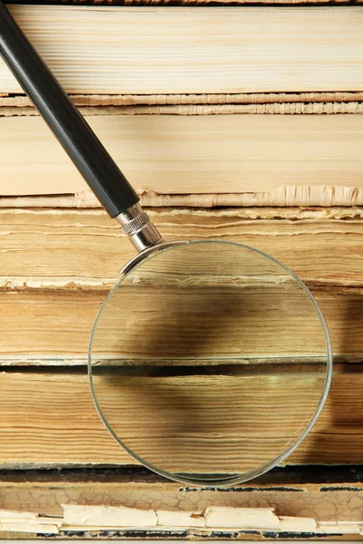 Magnifying glass over the stack of books — Stock Photo, Image