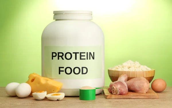 Jar of protein powder and food with protein, on green background — Stock Photo, Image