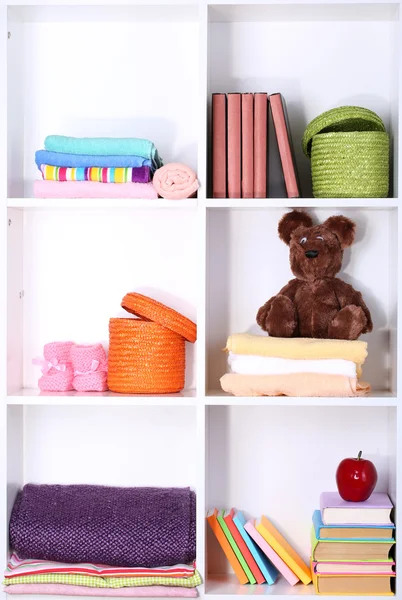 Hermosos estantes blancos con diferentes objetos relacionados con el bebé —  Fotos de Stock