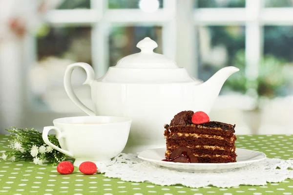 Tetera, taza de té y delicioso pastel en el fondo de la ventana —  Fotos de Stock