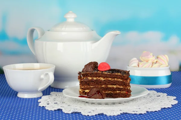 Czajnik, herbatę i pyszne ciasto na niebieskim tle naturalny — Zdjęcie stockowe