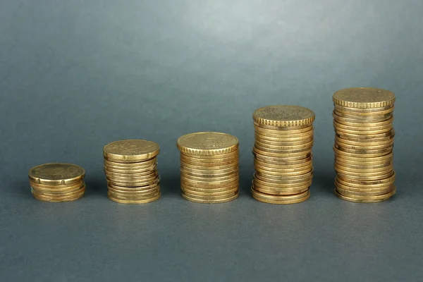 Many coins in columns on grey background — Stock Photo, Image