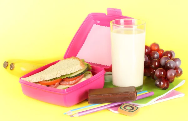 Lunch box with sandwich,grape,milk and stationery on yellow background — Stock Photo, Image