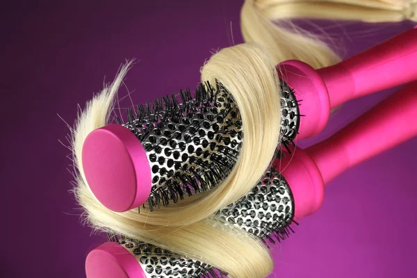 Comb brush with hair on purple background — Stock Photo, Image