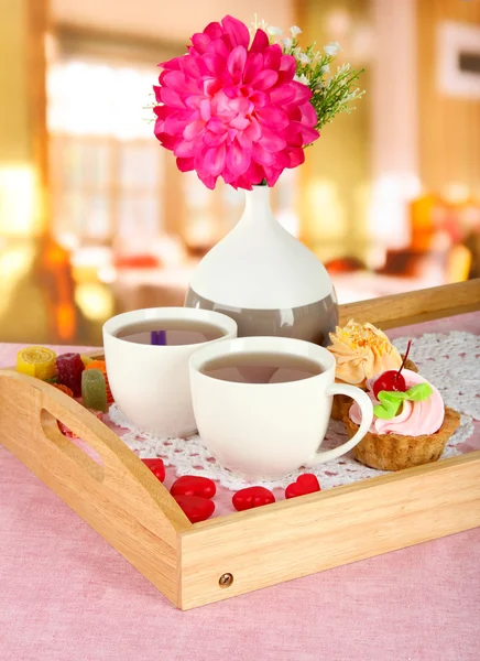 花とカフェのテーブル木製トレイ上のケーキと紅茶のカップ — ストック写真