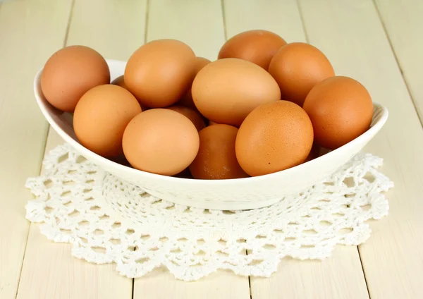 Αυγά σε λευκό μπολ σε κοντινό πλάνο ξύλινο τραπέζι — Φωτογραφία Αρχείου