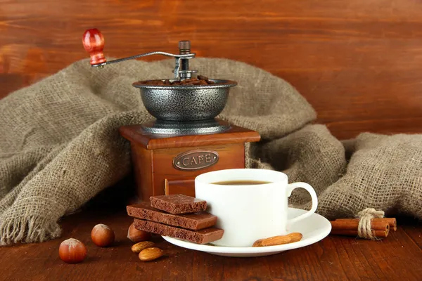 Dark chocolate, hot drink and coffee mill on wooden background — Stock Photo, Image