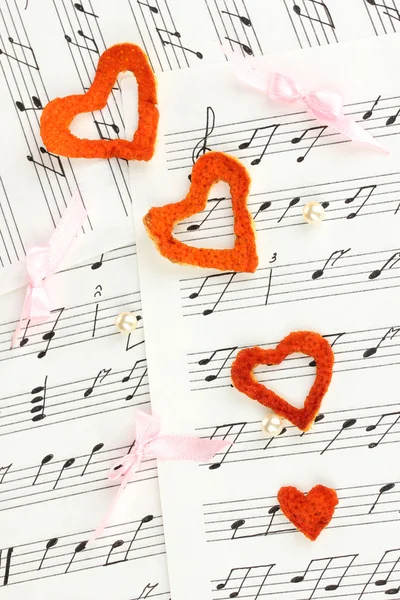 Dekorative Herzen aus trockener Orangenschale auf Noten — Stockfoto