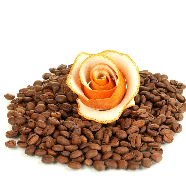 Decorative roses from dry orange peel on coffee beans heap — Stock Photo, Image