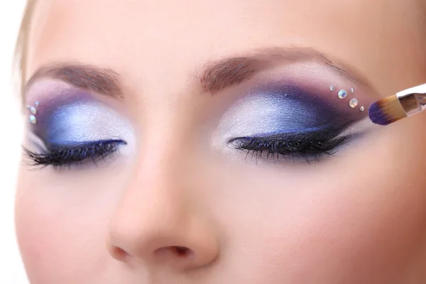Beautiful female eyes with bright blue make-up and brush Stock Image
