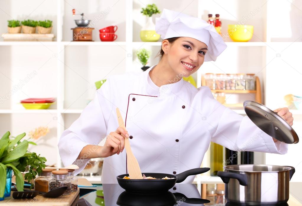 Young woman chef cooking in kitchen