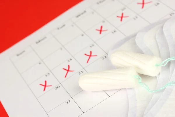 Calendário de menstruação com absorventes e tampões sanitários, close-up — Fotografia de Stock